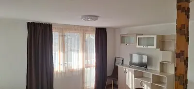 a living room with a window and a television at Студио Вили in Smolyan