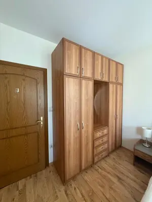 a bedroom with wooden cabinets and a bed and a table at Prime location one bed apartment with hydro bath in Royal Plaza in Borovets