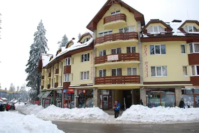 a large building with snow in front of it at Prime location one bed apartment with hydro bath in Royal Plaza in Borovets