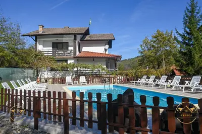 a villa with a swimming pool in front of a house at Къща за Гости БАРБЕЛ in Golyam Izvor
