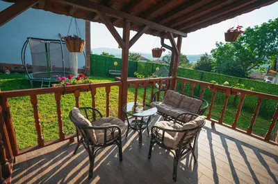 a deck with chairs and a table and a swing at Къщи за гости 'Веринско' in Verinsko
