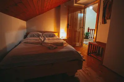 a bedroom with a large bed with a wooden ceiling at Къщи за гости 'Веринско' in Verinsko