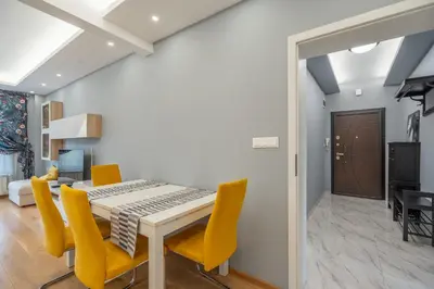 a dining room with a table and yellow chairs at Green Haven in Sofia