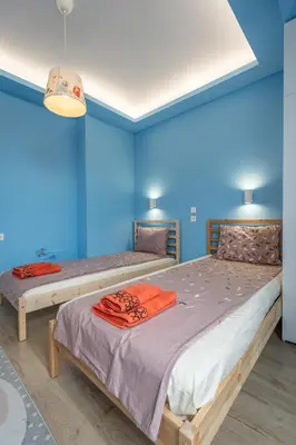 a blue bedroom with two beds with orange sheets at Green Haven in Sofia