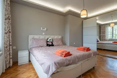 a bedroom with a large bed with orange pillows at Green Haven in Sofia