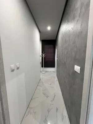 a hallway with marble flooring and a hallway with a door at Royalton Résidence in Plovdiv