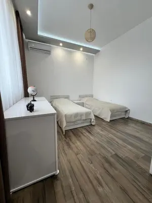 a white room with two beds and a table at Royalton Résidence in Plovdiv