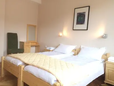 a bedroom with a large bed with white sheets at Hotel Hinovi Hvoyna in Hvoyna