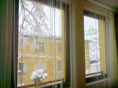 a window with a view of a building with snow at Hotel Hinovi Hvoyna in Hvoyna