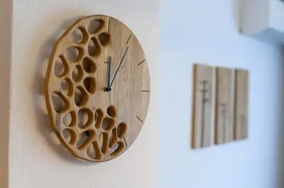 a wooden clock on a wall next to a thermometer at Cozy 2BDR & Peaceful Location & Free Street Parking in Blagoevgrad