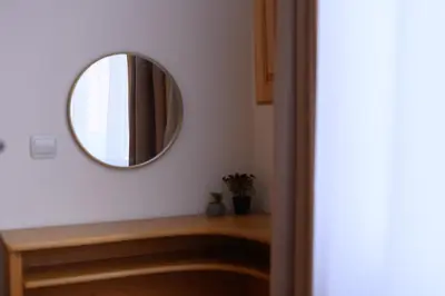 a mirror on a wall next to a wooden table at Cozy 2BDR & Peaceful Location & Free Street Parking in Blagoevgrad