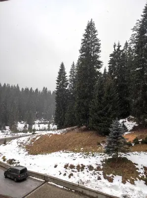 a car driving down a road in the snow at STRIM Apartment 406 Stream Resort, Pamporovo in Pamporovo