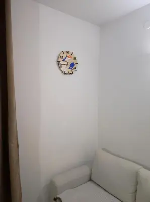 a room with a couch and a clock on the wall at STRIM Apartment 406 Stream Resort, Pamporovo in Pamporovo