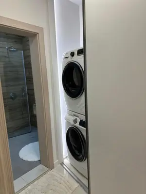 a reflection of a bathroom with a washing machine in a mirror at Delux 1 - Plovdiv Луксозен апартамент с паркинг in Plovdiv