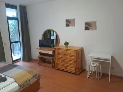 a bedroom with a bed and a dresser and a mirror at FLORA Apartment Hotel STUDIO 411 in Borovets