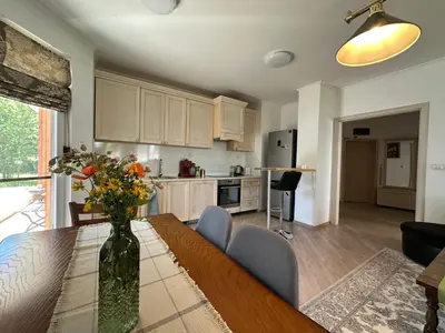a kitchen with a table with a vase of flowers on it at Cosy 2-bedroom apartment near the ski road Bansko in Bansko