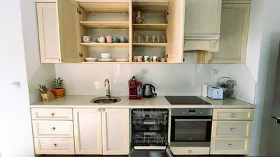 a kitchen with white cabinets and a sink and a dishwasher at Cosy 2-bedroom apartment near the ski road Bansko in Bansko