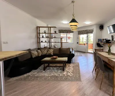 a living room with a couch and a table at Cosy 2-bedroom apartment near the ski road Bansko in Bansko