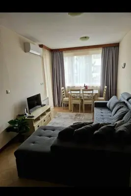 a living room with a couch and a dining room at Pirin Golf Hotel & Spa in Razlog