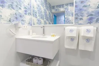 a white bathroom with a sink and towels at Lambrina Boutique rooms in Plovdiv