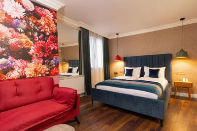 a bedroom with a bed and a red couch at Lambrina Boutique rooms in Plovdiv