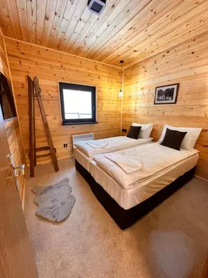 a bedroom with a large bed in a wooden room at Stylish Alpine Ski Chalet Tirol in Borovets