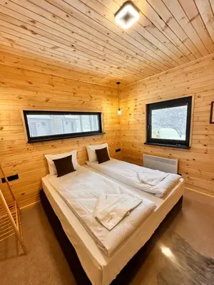a bedroom with a large bed in a wooden room at Stylish Alpine Ski Chalet Tirol in Borovets