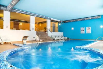 a swimming pool in a building with blue walls at Sun Stream Apartment in Pamporovo