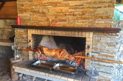 a pork roast cooking in a brick fireplace at Sun Stream Apartment in Pamporovo