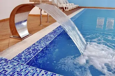a pool with a water fountain in a room at Alenik Private Apartment -The Stream Resort Pamporovo in Pamporovo