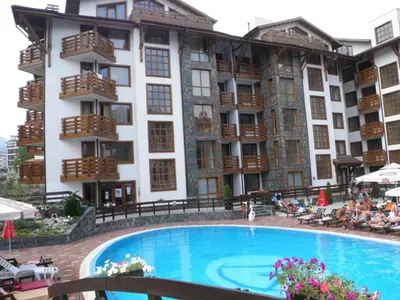 a hotel with a swimming pool in front of a building at Exclusive Ski and Spa Paradise Stylish Apartment in Bansko