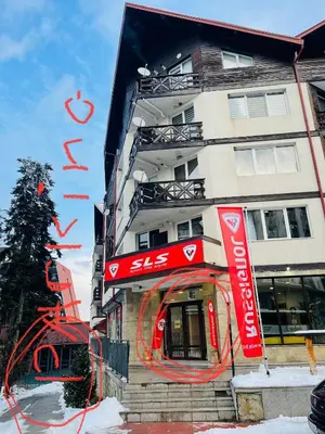 a building with red signs on the side of it at Snow Forest in Borovets