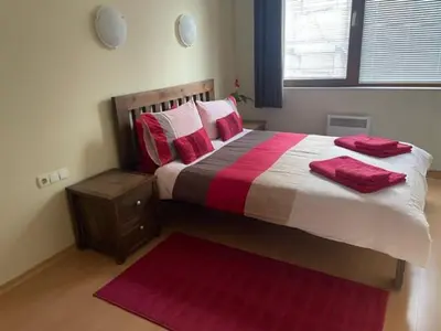 a bedroom with a large bed with red pillows at 27 Monastery in Bansko