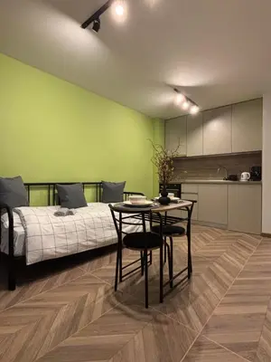 a bedroom with a bed and a table and a kitchen at Inspiration Nook in Sofia
