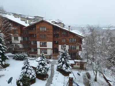 a large wooden building with snow on it at Slopes View Private Apartment - Luxury SPA in the 4-Star St Ivan Rilski Complex in Bansko