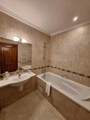a bathroom with two sinks and a tub and a mirror at Slopes View Private Apartment - Luxury SPA in the 4-Star St Ivan Rilski Complex in Bansko