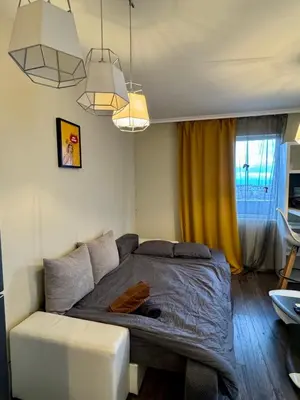 a bedroom with a bed and a yellow curtain at New Bulgarian Apartment in Sofia