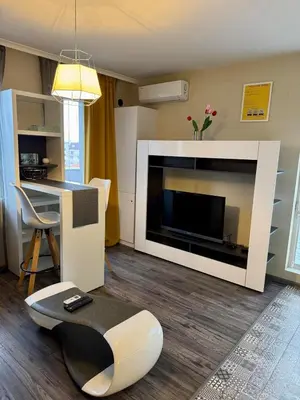 a living room with a television and a living room with a table at New Bulgarian Apartment in Sofia