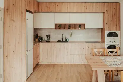 a kitchen with wooden cabinets and a wooden table at Apartment Aria 2 in Velingrad