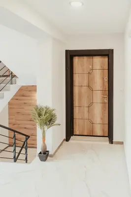a wooden door in a white room with a potted plant at Apartment Aria 2 in Velingrad