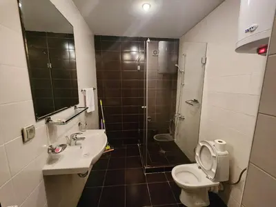 a bathroom with a shower and a toilet and a sink at Pirin View Apartment in Bansko