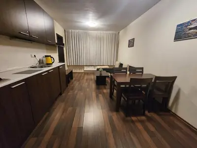 a kitchen and dining room with a table and chairs at Pirin View Apartment in Bansko
