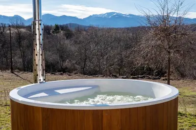 a bath tub in a field with mountains in the background at Гусу Баба in Kostenets Village