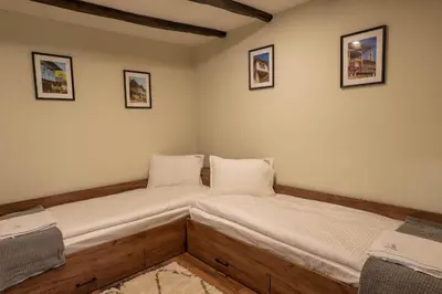 two beds in a room with wooden floors at Гусу Баба in Kostenets Village