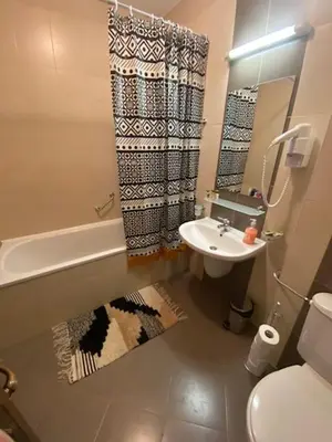 a bathroom with a sink and a toilet and a shower at St John Hill Alexander Services Apartments in Bansko