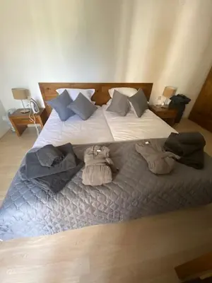 a bedroom with a bed with towels on it at St John Hill Alexander Services Apartments in Bansko