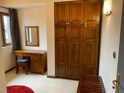 a room with a wooden closet and a desk and mirror at Elegant 3 Alexander Services Apartments luxury four bedroom penthouse in Bansko