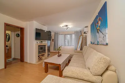 a living room with a couch and a tv at CrosswayBg Pamporovo in Pamporovo