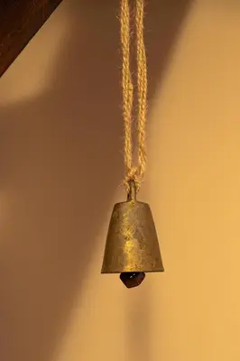 an old bell hanging from a chain at CrosswayBg Pamporovo in Pamporovo