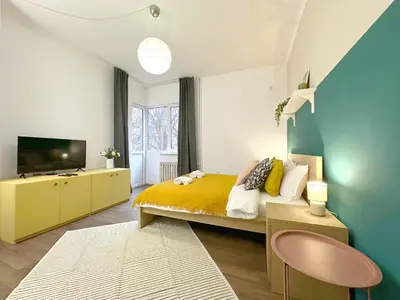 a bedroom with a yellow bed and a tv at Aurora Abode - Top Center 1 BDR Fast Wi-fi in Sofia